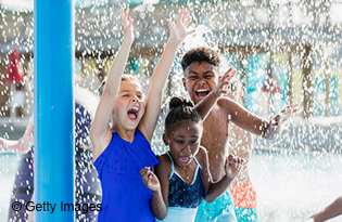 Safely make memorable summer stories: Group of children playing at a water park