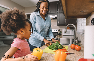 Mother and daughter cutting vegetables