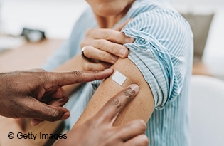 Hands putting bandage on patient arm